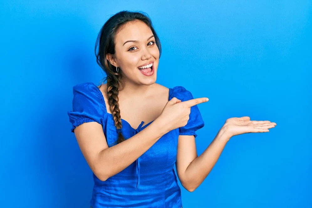 jeune femme hispanique pointant à gauche